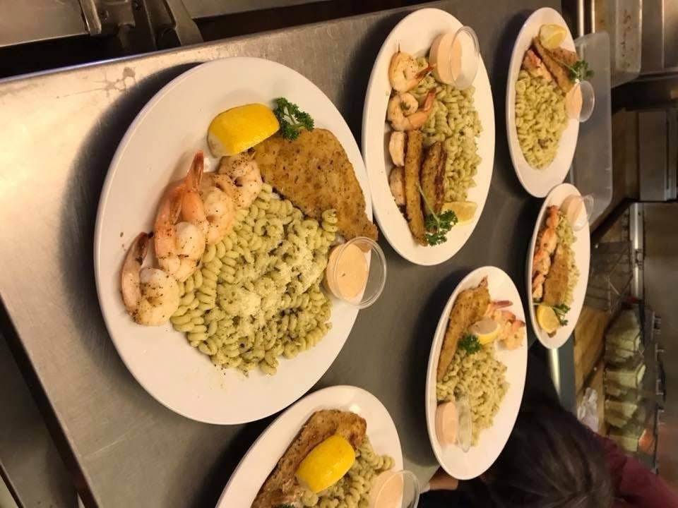 Elegant sit down dinner plate shrimp and posta with pesto